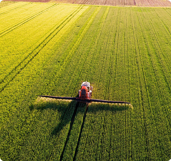 Combine harvester spraying a field